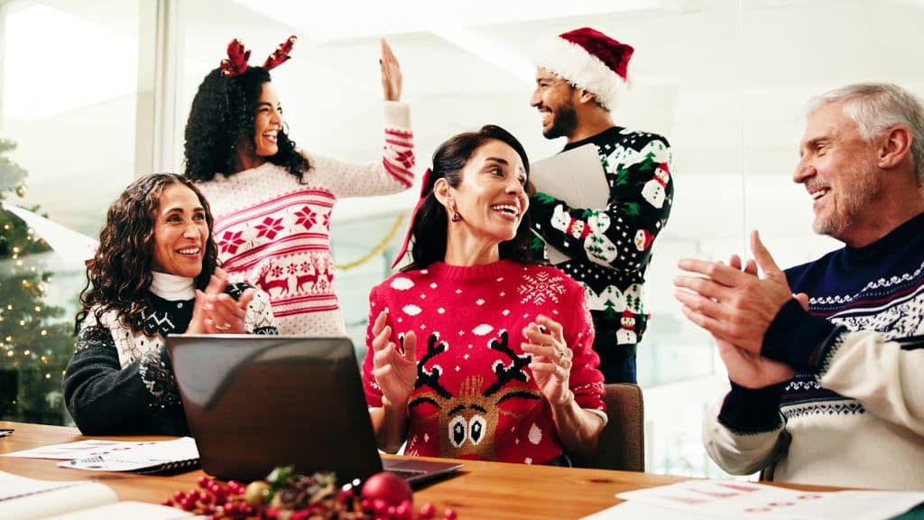 Equipo de empresa celebrando la Navidad en la oficina con regalos corporativos sostenibles de Artsport Publicidad.